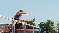 Eine Hürdenläuferin springt über eine Hürde im Wettkampf