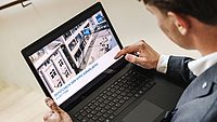Mann schaut auf einen Laptop